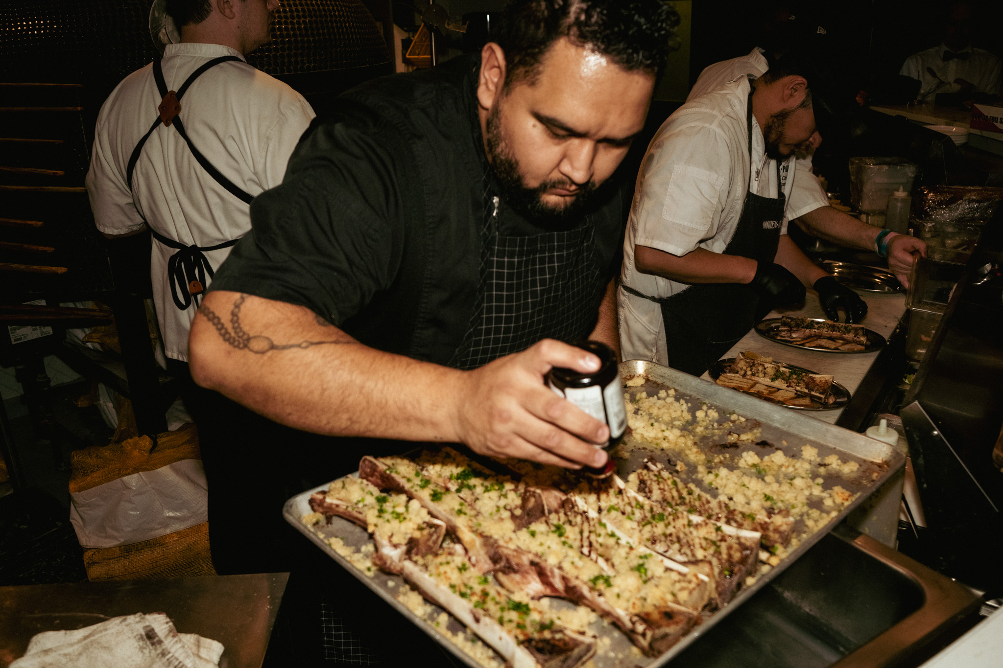Chef finishing a wood-fired pizza