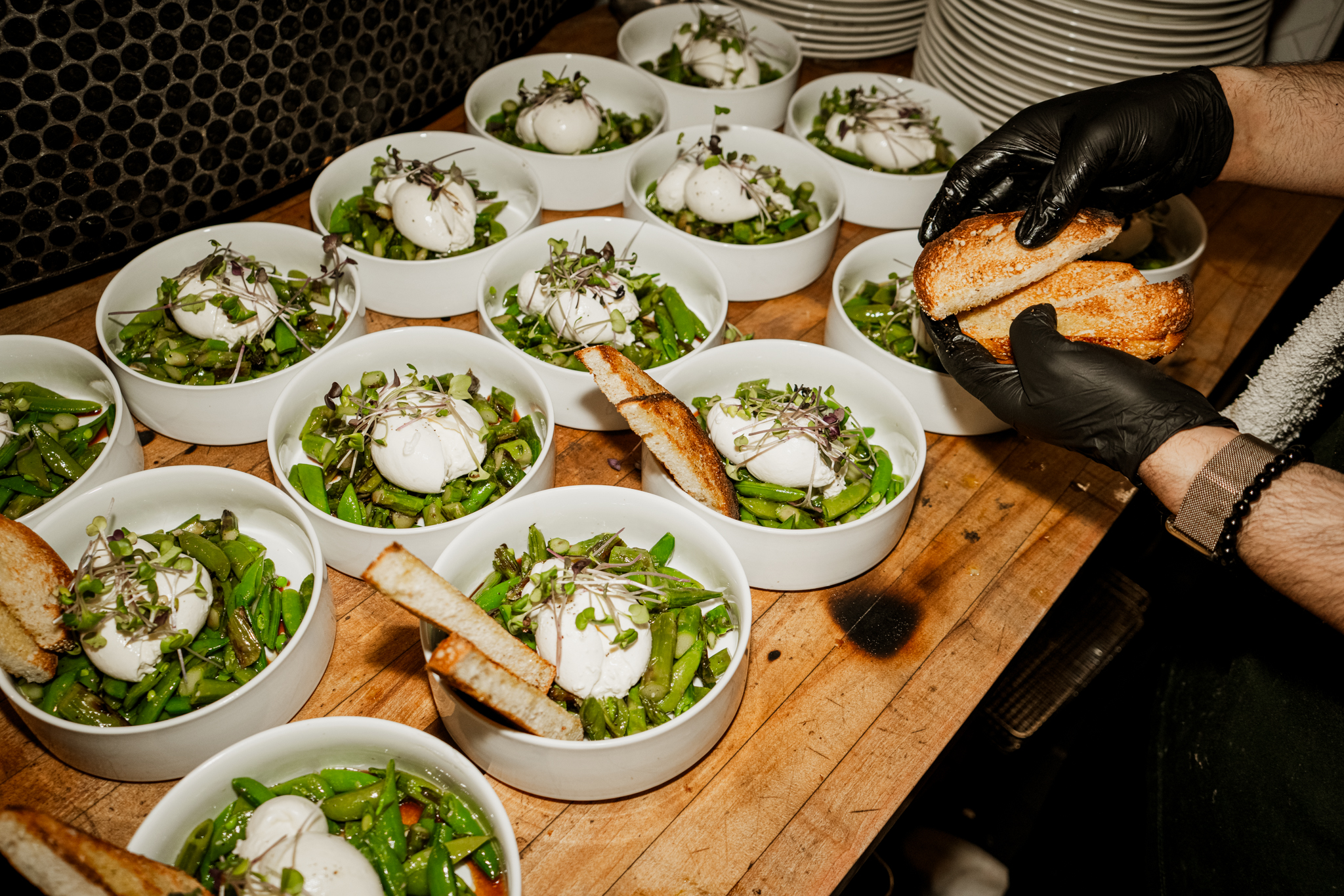 Burrata salads lined up on the pass